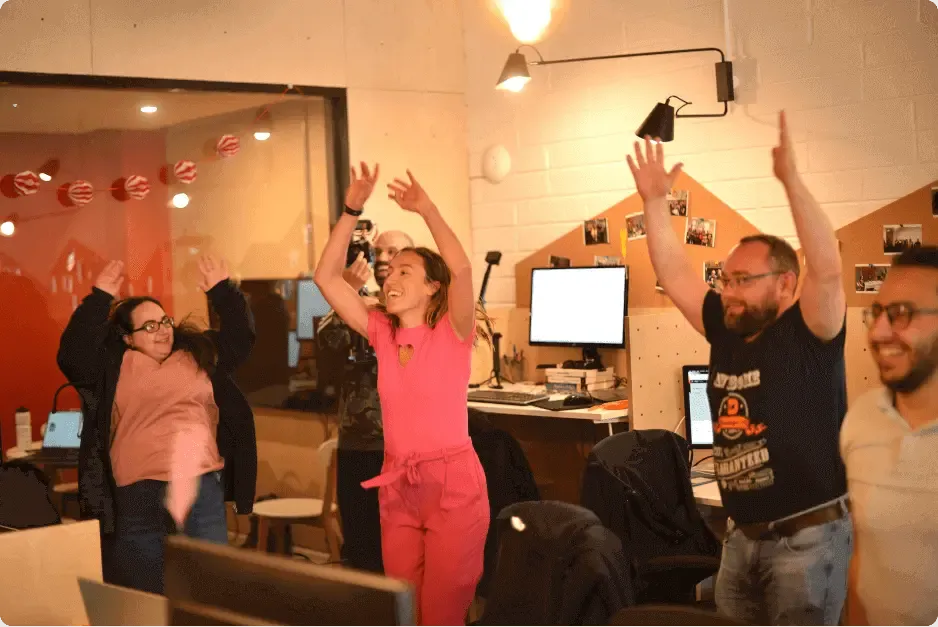 The OnePageCRM team celebrating in the Galway office, arms in the air