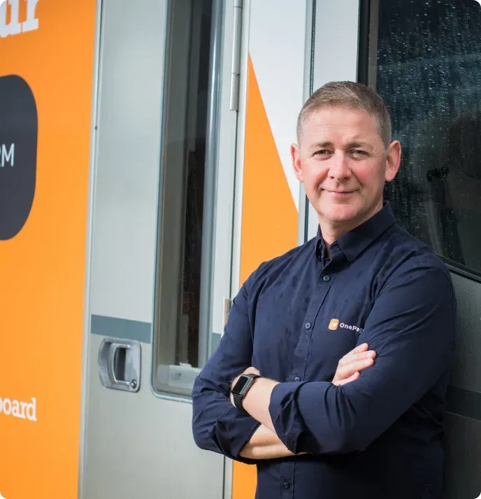 Michael FitzGerald standing beside the orange OnePageCRM camper van on the 2018 customer tour