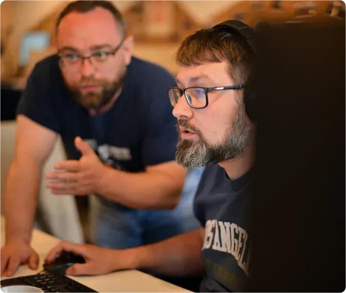 Two OnePageCRM engineers working through a problem at a screen together