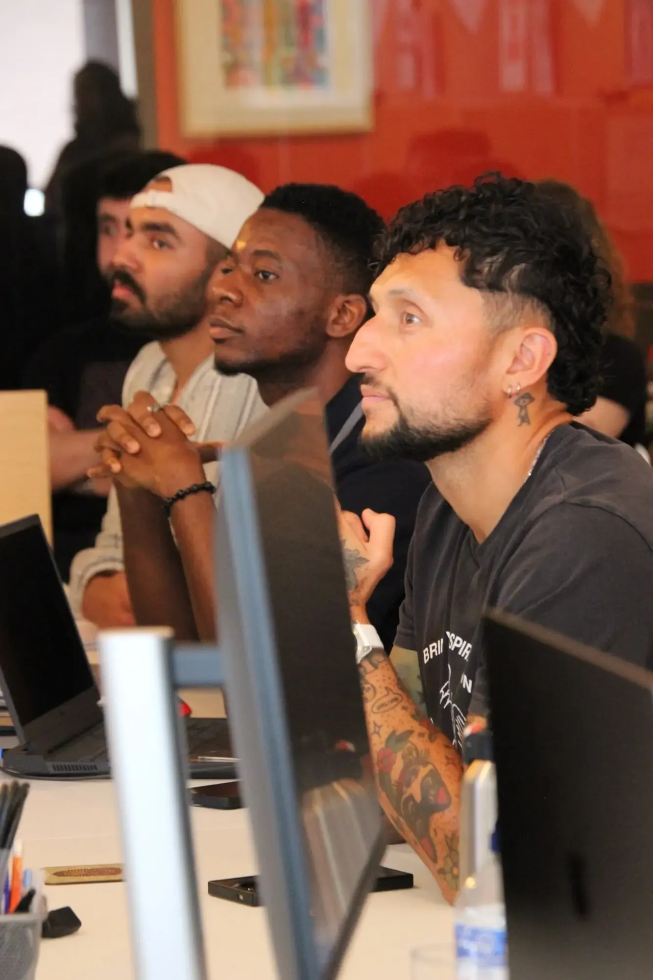 Three of the team watching a presentation together in the office