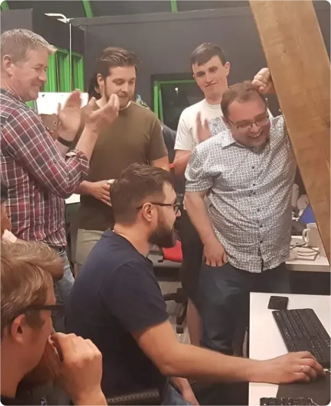 The early OnePageCRM team crowded around a desk in the Galway office, laughing